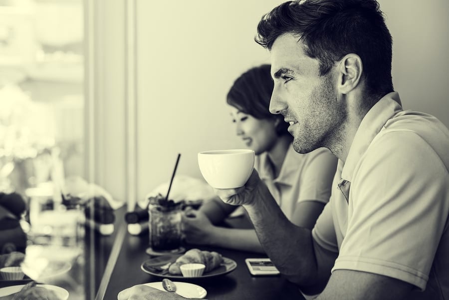 Man sipping coffee and eating